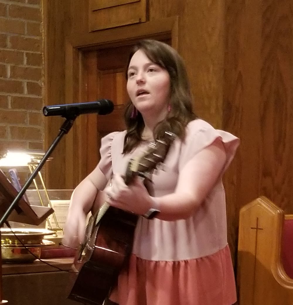 Katie Moore, Worship Leader at Herbert UMC, singing and playing guitar